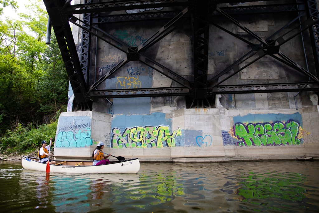 Trails Youth Initiative canoes past a wall of graffiti